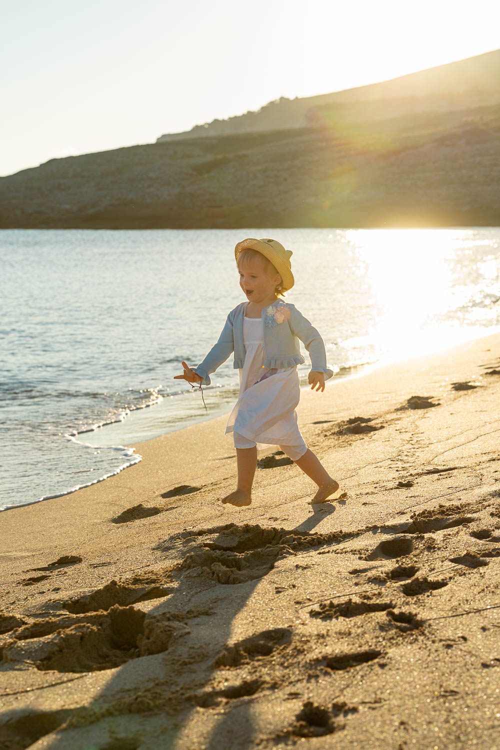 Familien Foto Mallorca - Kind läuft am Strand entlang, Eltern im Hintergrund